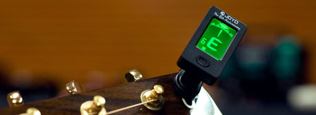Afinador JOYO JT-01 encendido y colocado en la pala de una guitarra