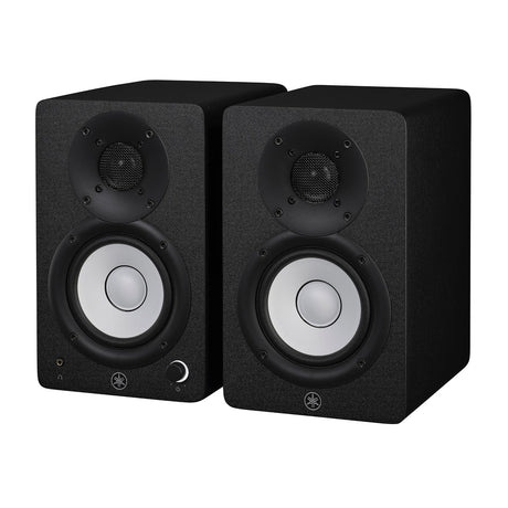 Par de monitores de estudio Yamaha HS4 negros, vista diagonal sobre fondo blanco